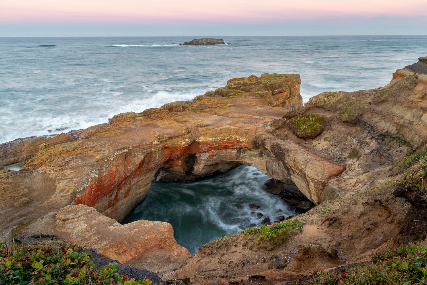 Devil's Punchbowl rock formation with ocean waves flooding the cavern