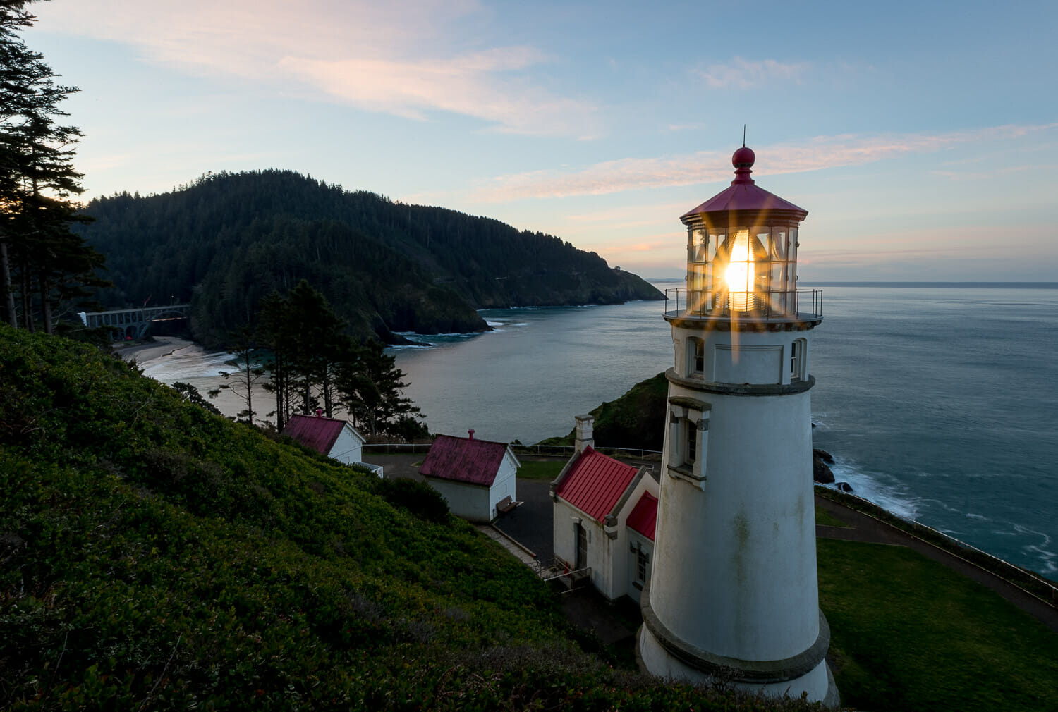 Oregon's Heceta Head lighthouse shining over the ocean at sunrise