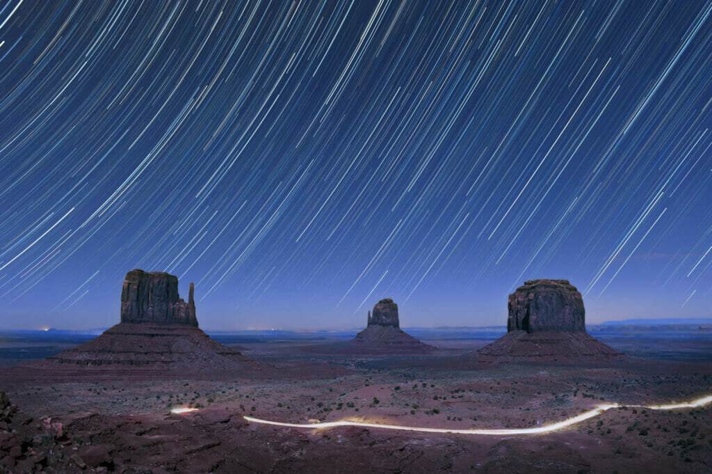 Star trails line the sky above monument valley, usa.